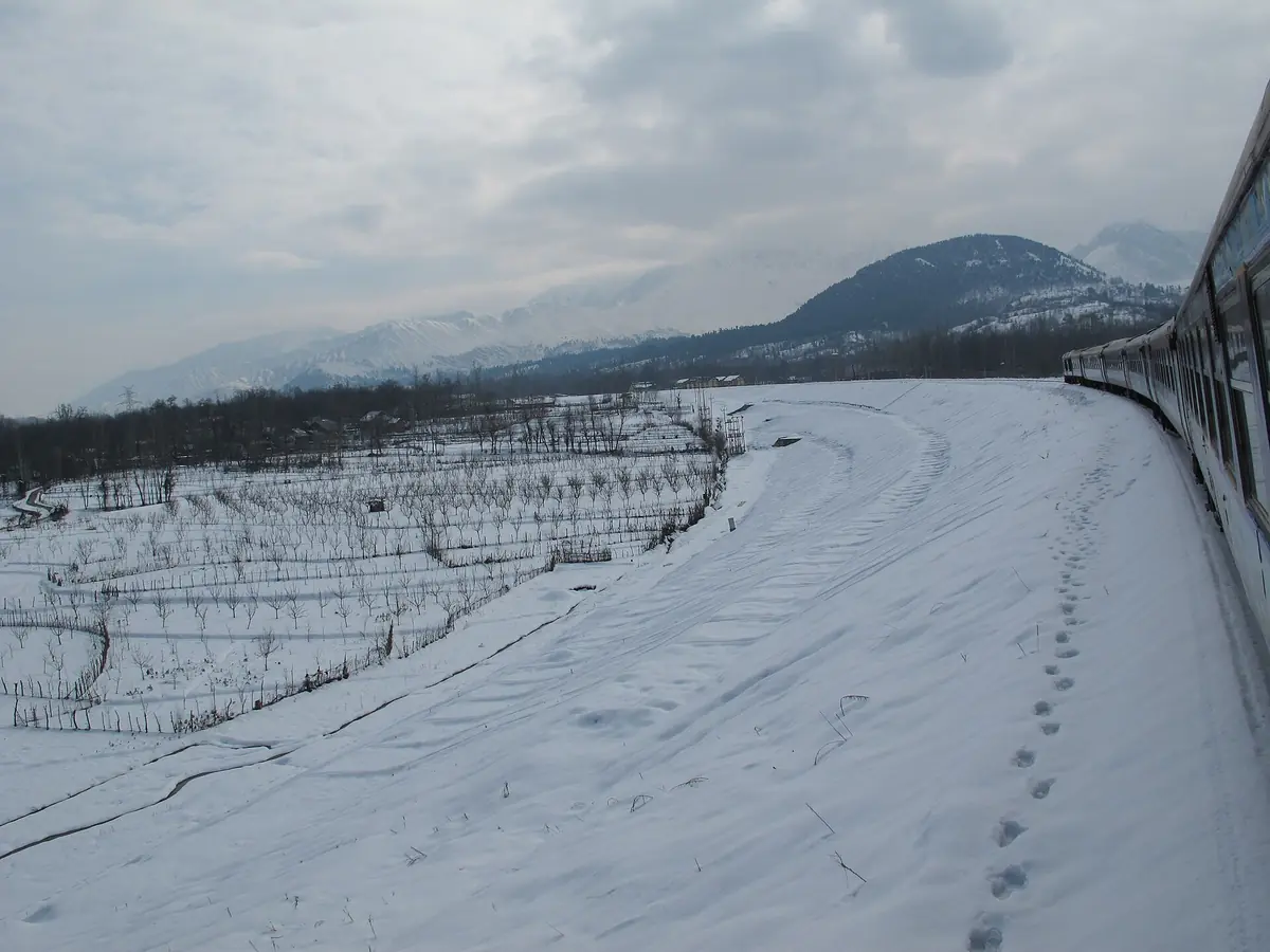Snow-covered fields near Qazigund, seen from a Baramulla–Banihal train in January
